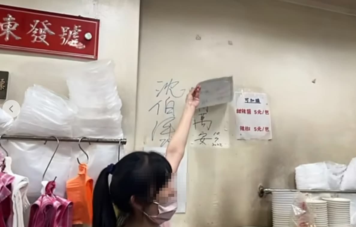 沈伯洋光顧百年老店「東發號麵線」時，店家邀請他幫忙簽名，並掀開「蓋住」許久的蔣萬安簽名。（翻攝自周軒臉書）