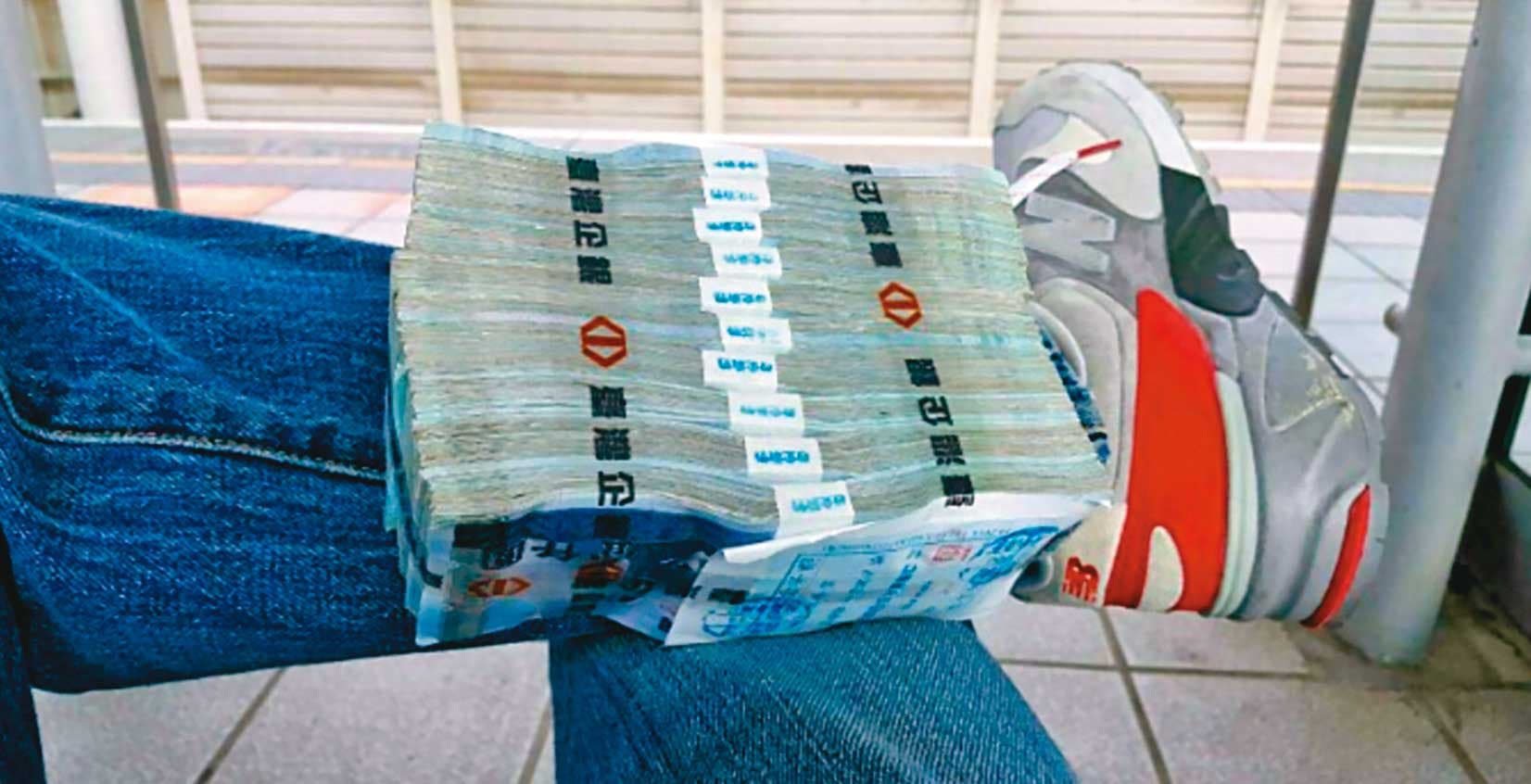 為了取信被害人，張錦生故意將大筆現金放在腳上拍照炫富。（讀者提供）