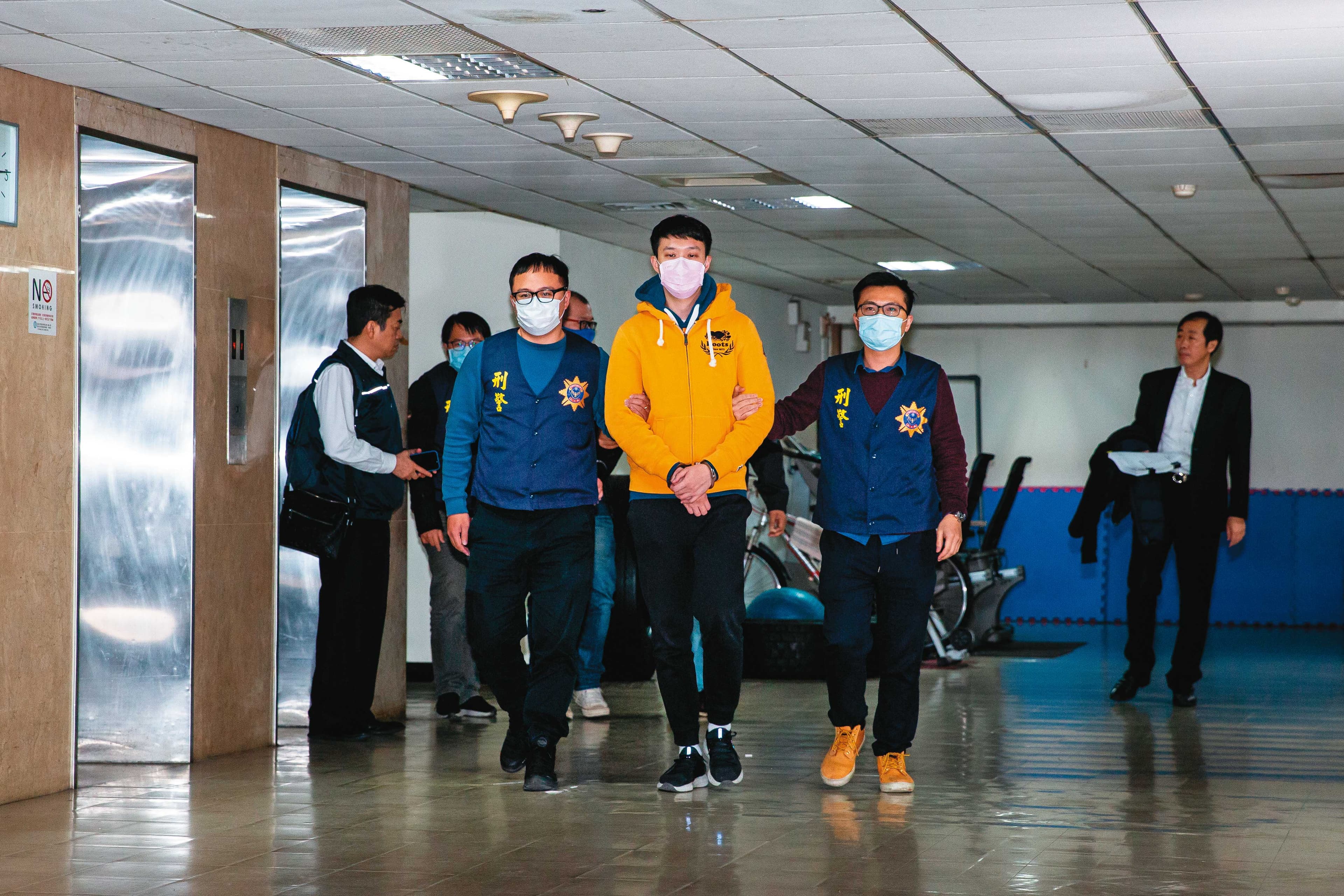 余姓男子(黃衣者)架設網站販賣不雅片,被法院判刑2年10個月。