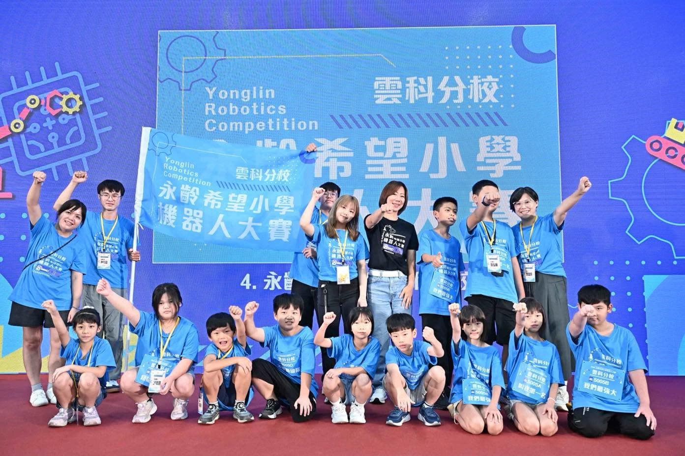 郭曉玲（黑衣者）出席第二屆永齡希望小學機器人大賽，與參賽學童合影。（永齡基金會提供）
