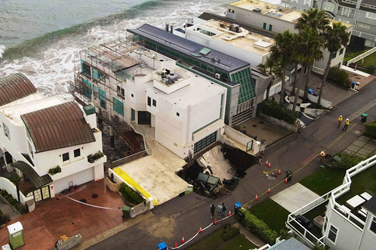 從空中俯瞰可見天坑緊貼尼可拉斯凱吉豪宅,大片路面及車道坍塌,豪宅另一側就是海岸,畫面相當驚人。(翻攝X@SuisseSUI)