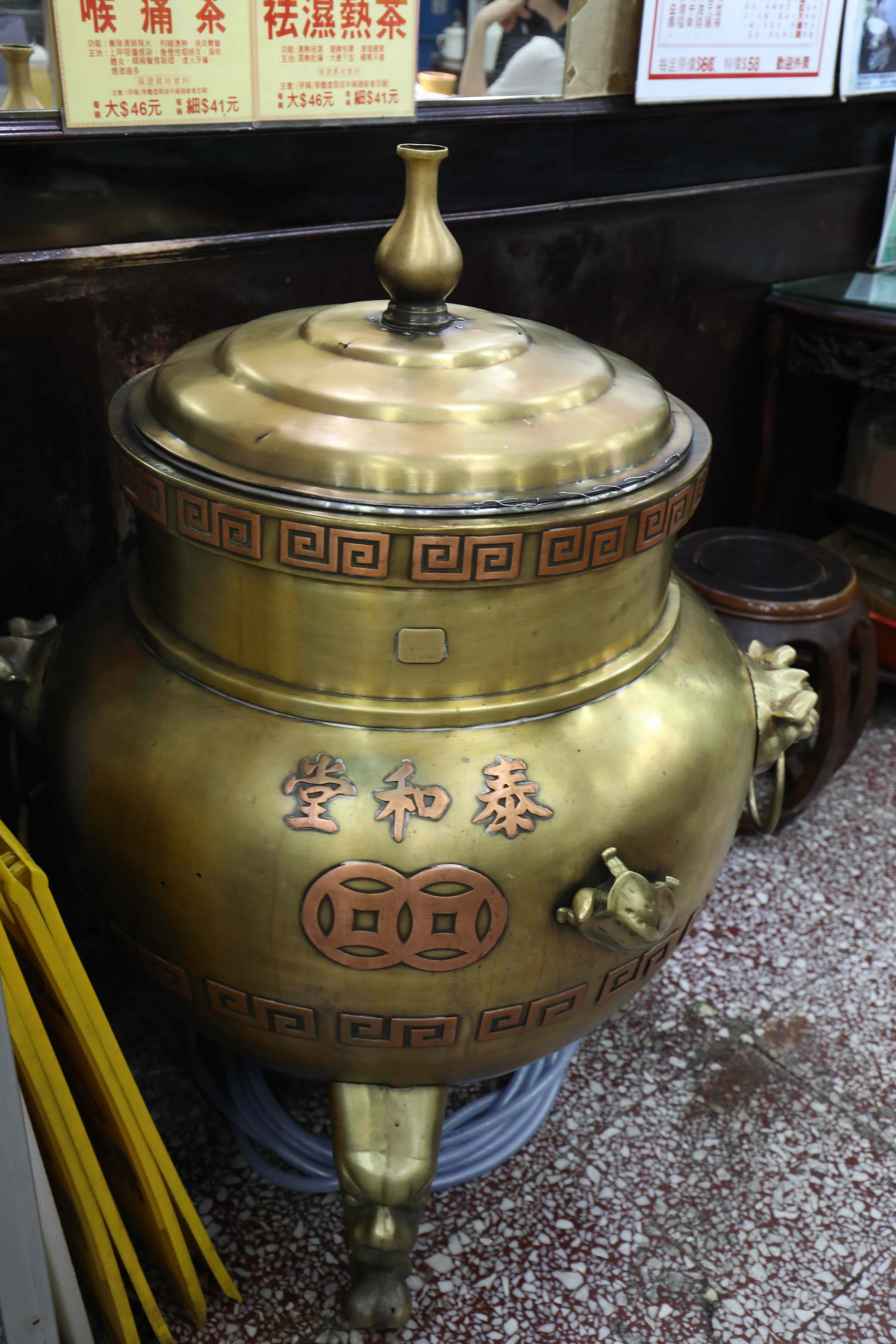 店內擺放的大型黃銅爐鼎是老物件，老闆說已經很難買到了，裡面盛放著一碗碗龜苓膏。